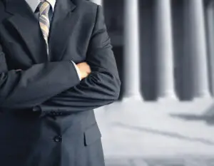 A DUI lawyer wearing a suit and arms folded.