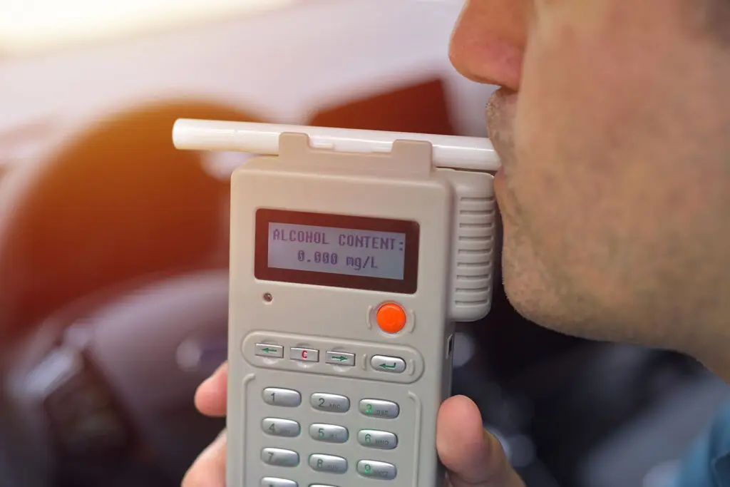 A man blows into a breathalyzer test.