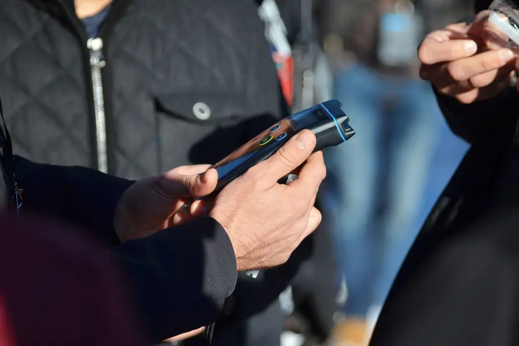A man holding a breathalyzer and checking out the results.