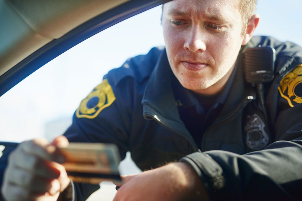 A police officer inspects a driver's license.